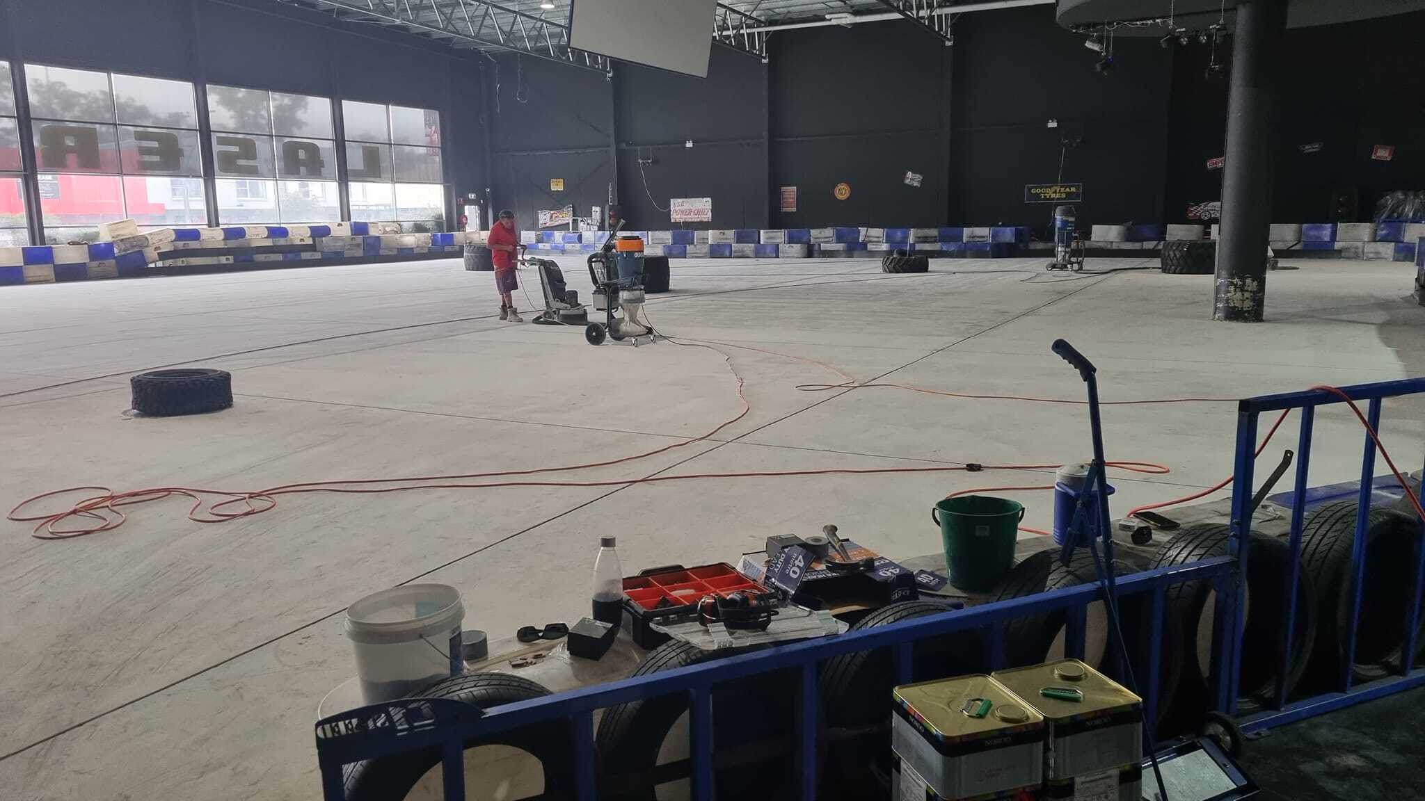 Ground concrete floor of an indoor kart track with tools on a table in front