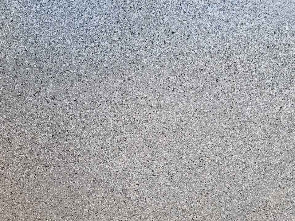 Close-up of a grey and white speckled flake floor finish