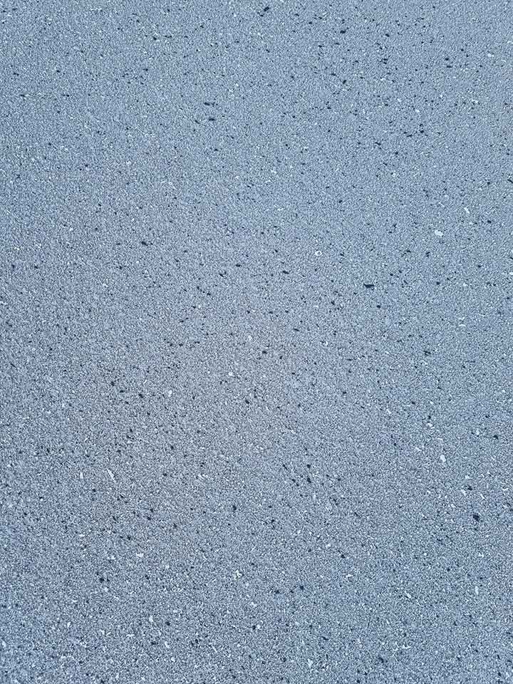 Close-up of a smooth grey concrete surface with fine flecks