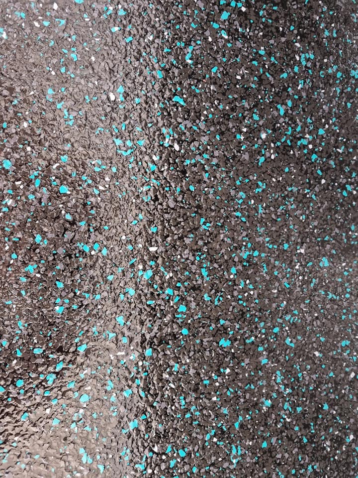 Close-up of a dark floor coating with turquoise flecks