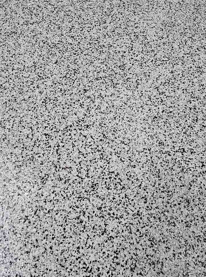 Close-up of a white flake floor coating with black flecks