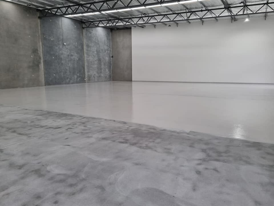 Warehouse floor with light grey coating meeting the ground concrete