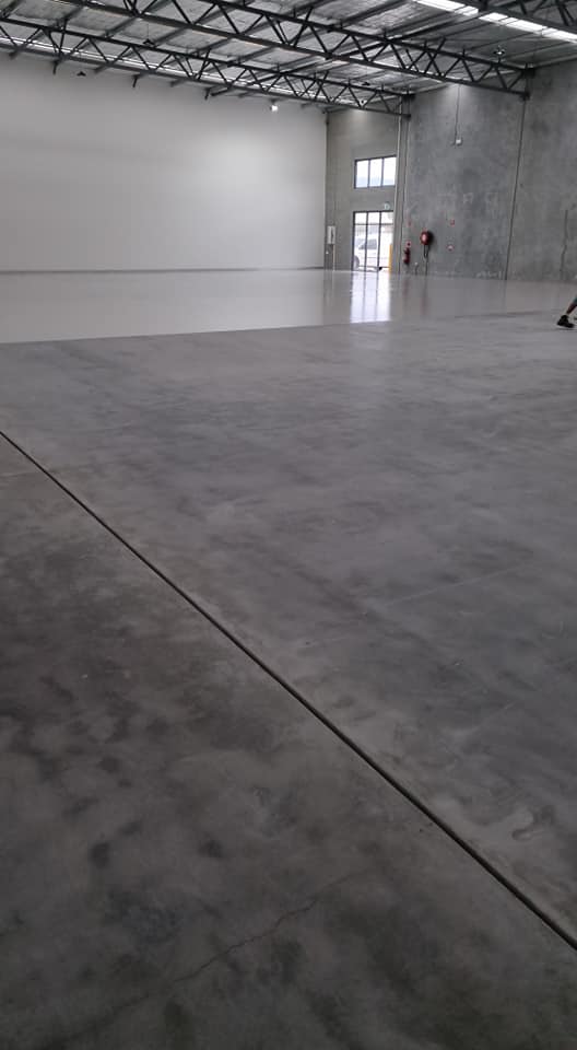 Ground concrete floor in a large warehouse, portrait view