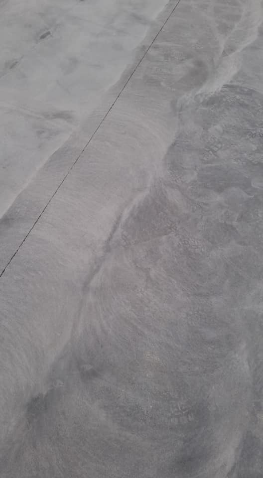 Close-up of a ground concrete floor with a saw-cut joint