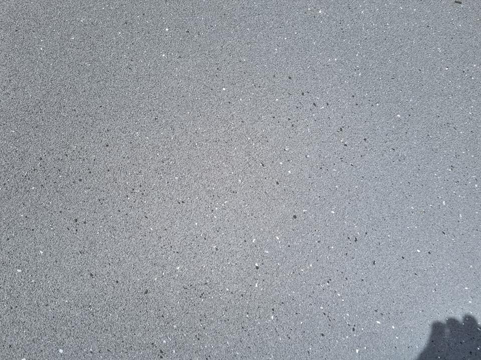 Close-up of a resurfaced grey concrete surface with small flecks