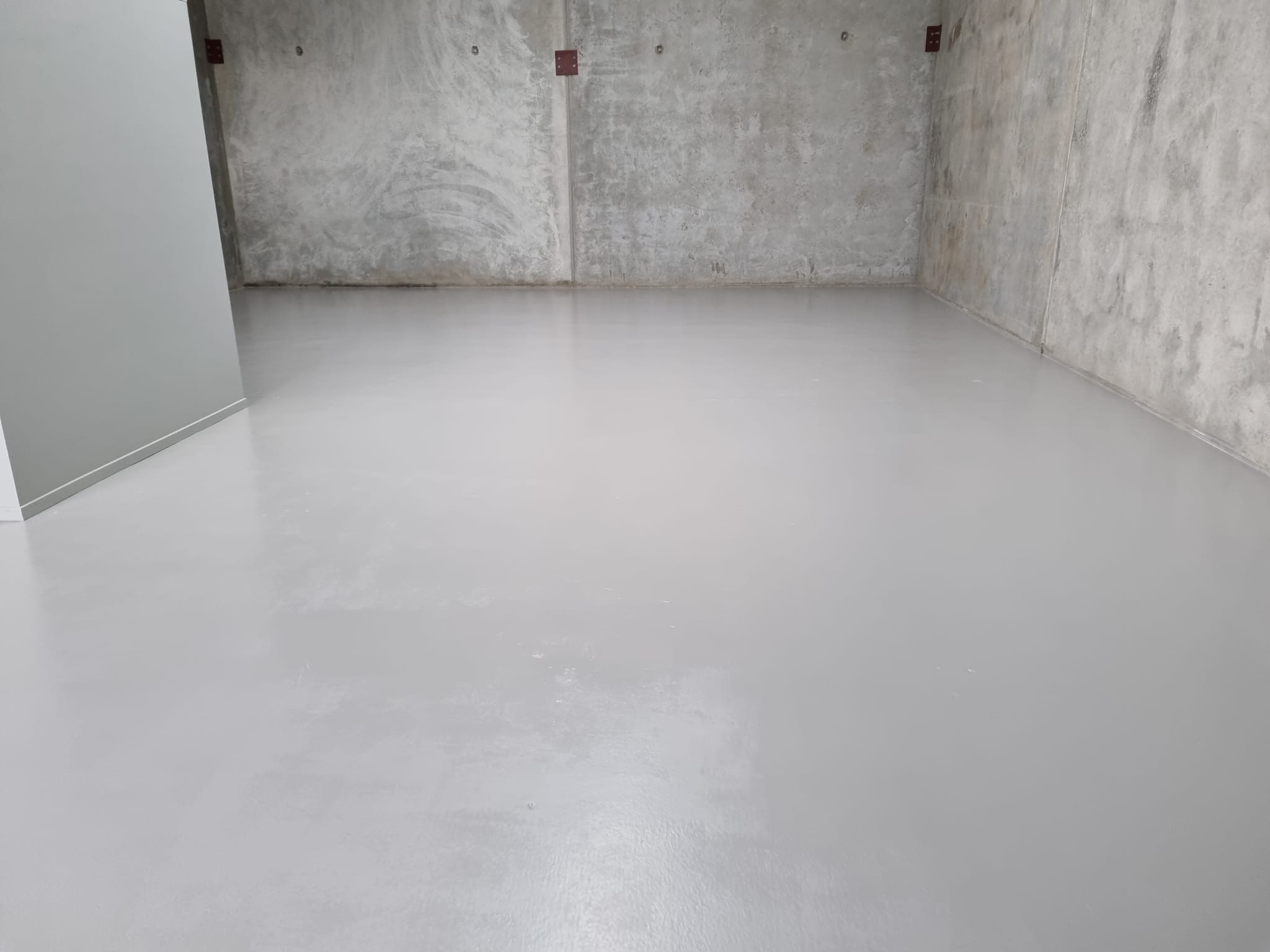 Light grey floor coating in a concrete-walled storage room, another angle