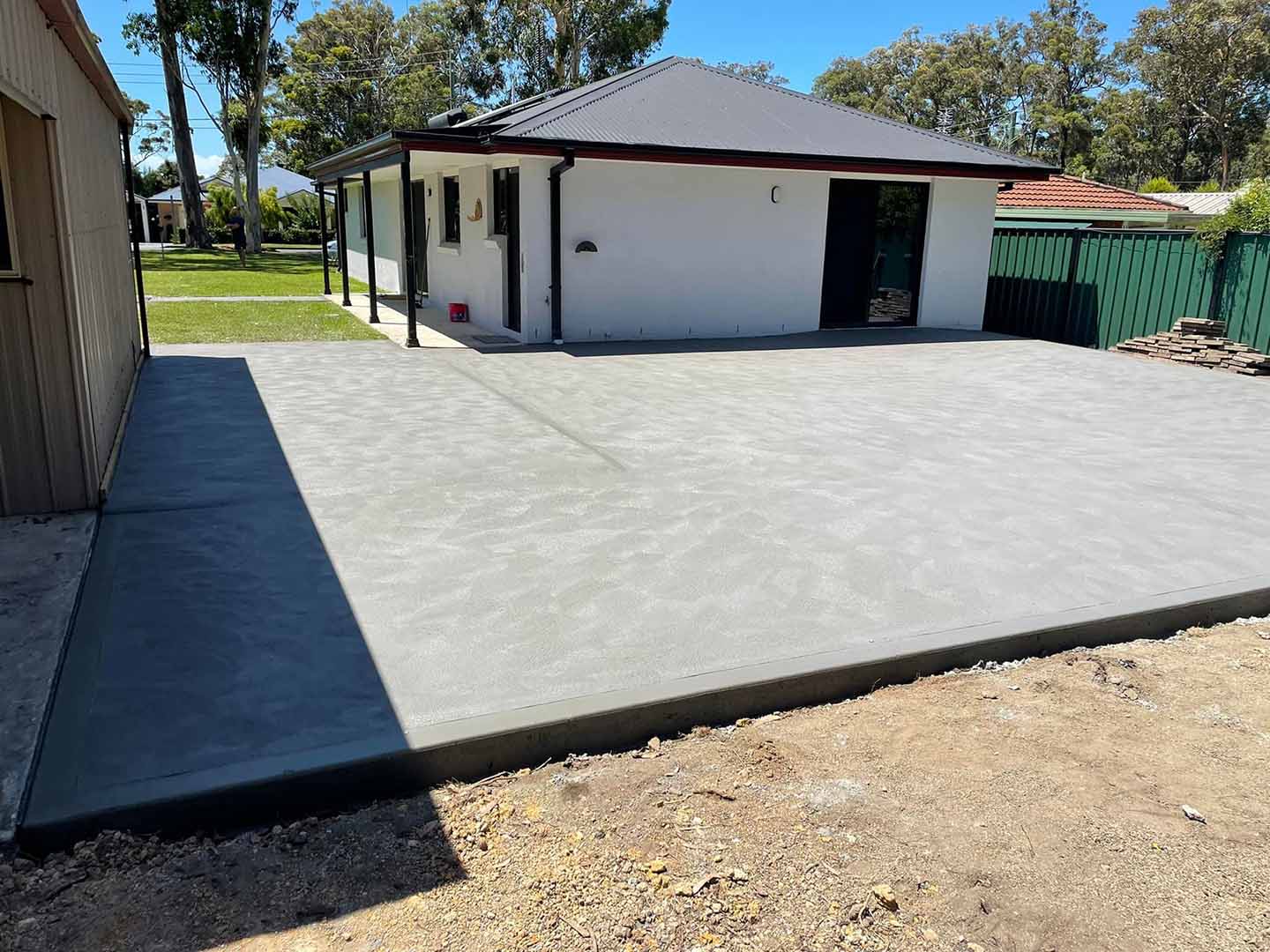 New concrete slab beside a shed, viewed from the side