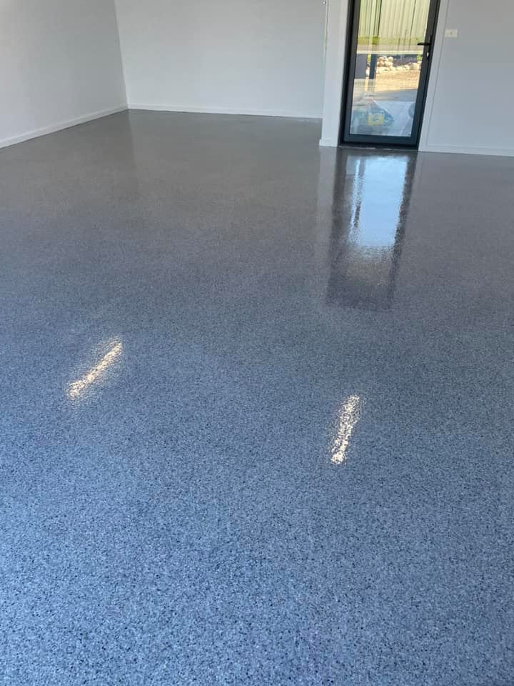 Glossy speckled floor coating in an empty room with a glass door