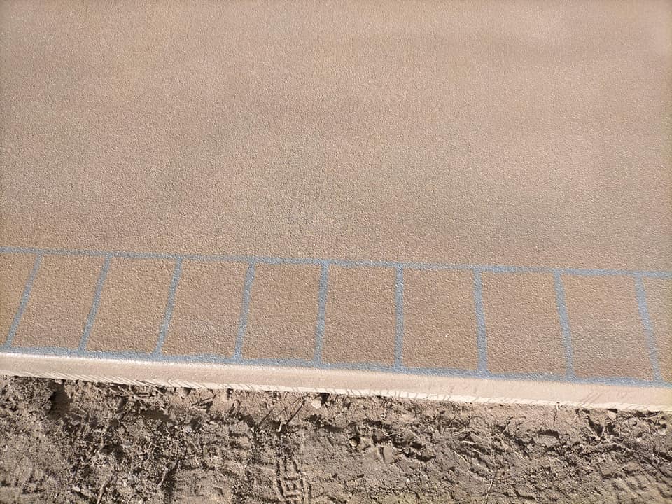 Close-up of a resurfaced porch edge with a tile-pattern border