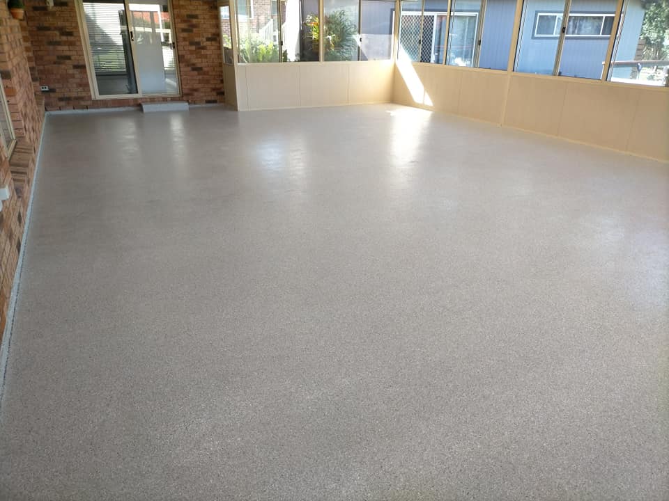 Speckled floor coating across a large sunroom with windows