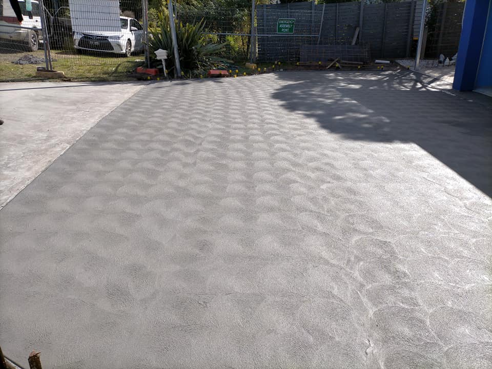 Grey textured resurfaced driveway with a fan pattern