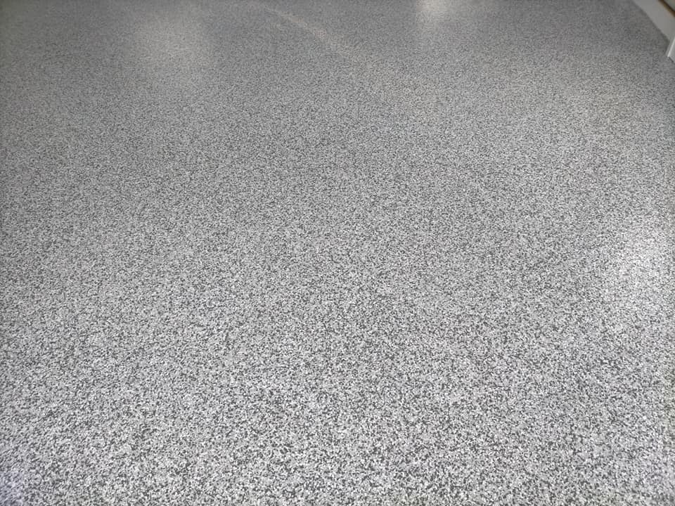 Close-up of a grey and white flake floor coating