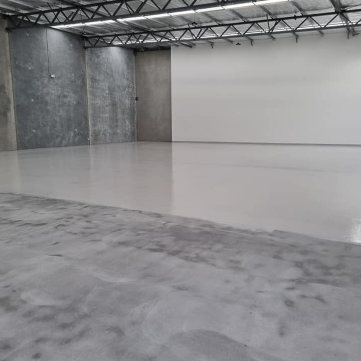 Large warehouse floor half coated in light grey