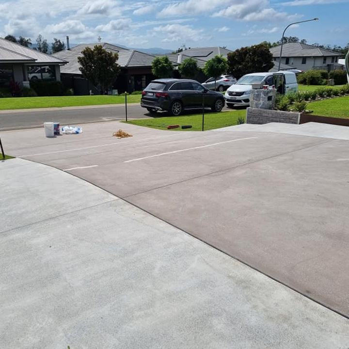 Two-tone grey and red-brown resurfaced driveway in a new housing estate