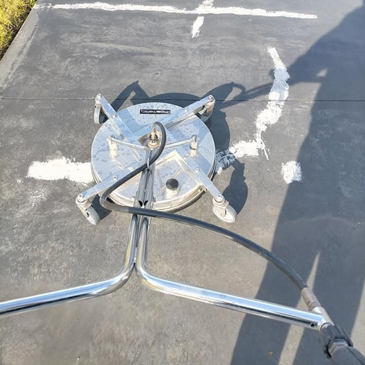 Rotary surface cleaner on a charcoal concrete surface